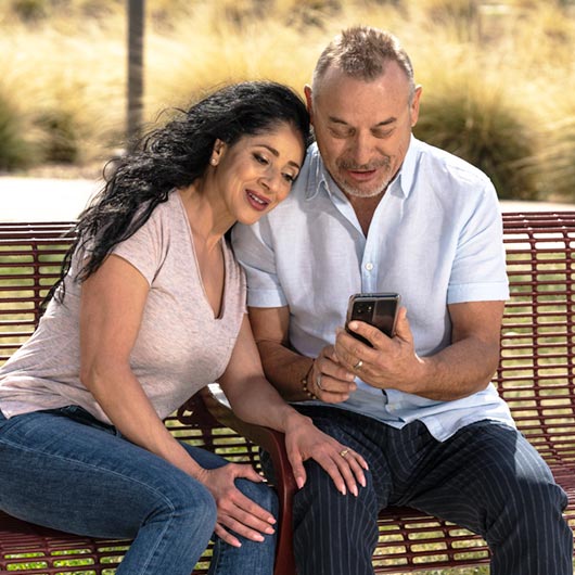 pareja mirando el dispositivo móvil juntos