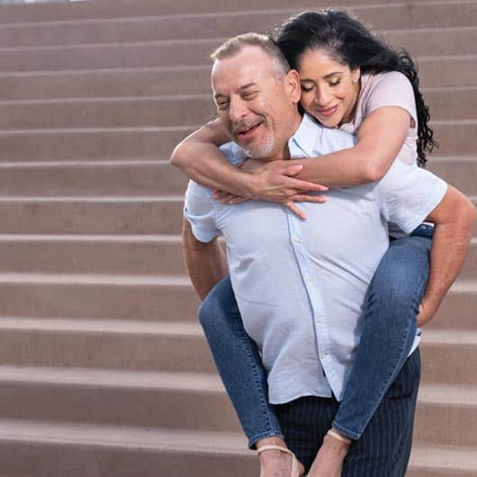 esposa yendo a cuestas de su esposo en unas escaleras