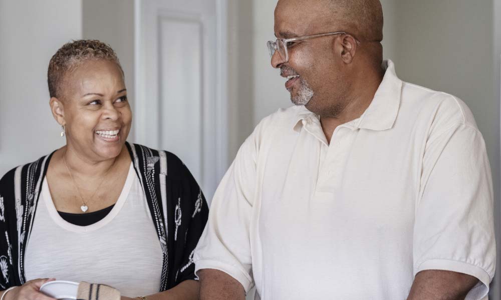 tony-and-cece - La Bombita | Salud del hombre de Coloplast Tony, un receptor del implante peniano Titan® y del cabestrillo masculino Virtue® y su pareja, Cece, sonriéndose el uno al otro en la cocina de su hogar